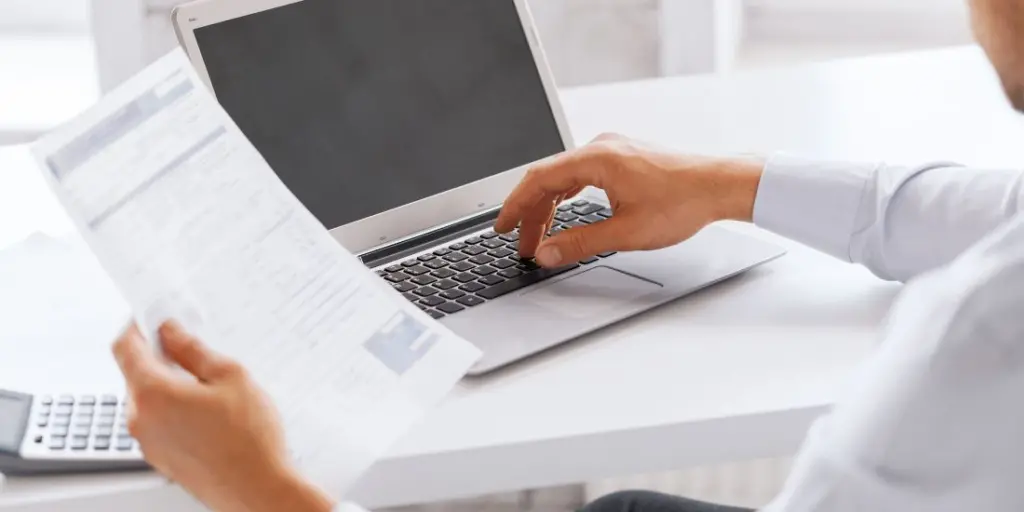 Professional die administratieve taken uitvoert op een laptop met behulp van Office Angels’ ondersteuningsdiensten voor verhoogde efficiëntie in klantcontact.