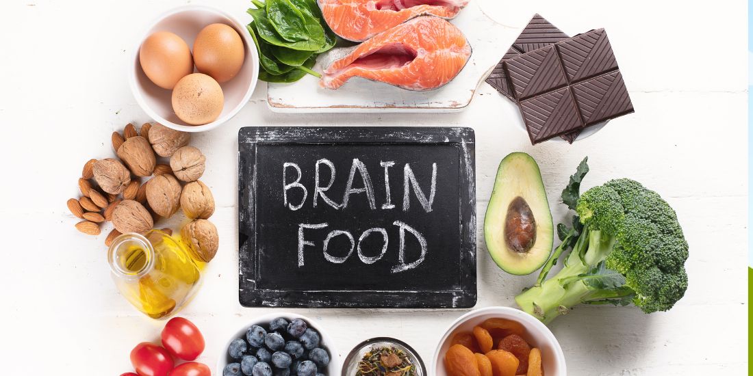 Een afbeelding van het woord "Brainfood" in het midden, omringd door verschillende voedingsmiddelen die goed zijn voor het brein, zoals vette vis, groene bladgroenten, volle granen en noten, een bron van inspiratie voor Office Angels.
